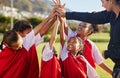 High five, team and girls soccer celebrate a victory and win on field with coach. Sports. young and female children