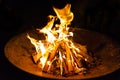 High flames from a burning wood fire on a metal grate at night. Royalty Free Stock Photo