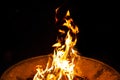 High flames from a burning wood fire on a metal grate at night. Royalty Free Stock Photo