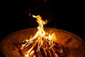 High flames from a burning wood fire on a metal grate at night. Royalty Free Stock Photo