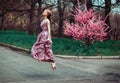 High flying success and joy for happy slim young woman wearing long dress, jumping into the air outdoors in countryside Royalty Free Stock Photo