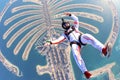 High. Man flies like a bird. Fly men in white suit. Extreme is a hobby for courage people. Air sport as a way of life.