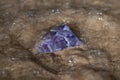 High grade rough natural Purple Auralite 23 Amethyst point from Canada on wet sand in front of the lake at sunrise