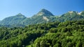 High green mountains with cable lifts. Blue clear sky