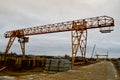 High heavy yellow metal iron load-bearing construction stationary industrial powerful gantry crane of bridge type on supports Royalty Free Stock Photo