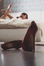 High heels in front of female bedroom defocused. Sexy erotic woman relaxing on bed. Attractive female relax. Erotic Royalty Free Stock Photo