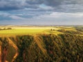 High hills with fields of grass and groves of birches.