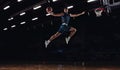 Young African sportsman, basketball player jumping high isolated on dark background. Concept of sport, game, competition Royalty Free Stock Photo