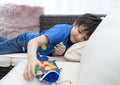 High key happy kid stay at home lying on sofa playing with Koinobori Carp streamers,Child boy doing Japanese fish kite in sunny Royalty Free Stock Photo
