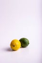 A high-key photograph of a yellow lemon and green lime.