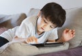 High key portrait Kid stay at home relaxing in living room in summer,Happy Child boy lying on sofa watching cartoon or playing Royalty Free Stock Photo