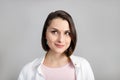 High key portrait of thinking young brunette multiethnic woman in pink tank and white shirt looking at top corner