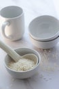 High key white rice in bowl with cup and spoon. Royalty Free Stock Photo
