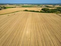 High level aspect view over a wheat field with bales of straw ready for collection in the English countryside Royalty Free Stock Photo