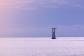 high lighthouse tower white and red color near sea shore port. construction building for navigator and signal safety. calm place Royalty Free Stock Photo