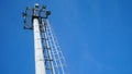 High lighting mast against the blue sky. View from below. Full height. Royalty Free Stock Photo