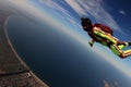 High. Man flies like a bird. Fly men in green suit. Extreme is a hobby for courage people. Air sport as a way of life.