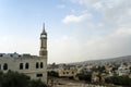 High Minaret at the Muslim mosque against the blue sky and the city on the hill. middle East.