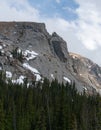 A high mountain cliff stands tall over the forest Royalty Free Stock Photo