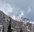 A high mountain cliff stands tall over the forest Royalty Free Stock Photo