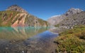 High-mountain lake, treeless steep slopes. Green water, stones at the bottom, a wild place.