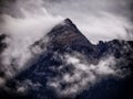 High mountain peak covered by fog and mist