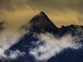 High mountain peak covered by fog and mist