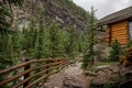 High mountain village - a stone path, a wooden fence in forest and the slopes of the Rocky Mountains. dramatic tone Royalty Free Stock Photo