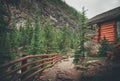 High mountain village - a stone path, a wooden fence in forest and the slopes of the Rocky Mountains. dramatic tone