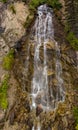 High mountain waterfall cascades over rock