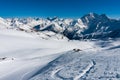 High mountain winter view with snowboarder and skier riding down the glacier to the valley.