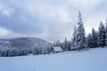 High on the mountains in the forest covered with snow there is lonely old wooden hut. Royalty Free Stock Photo