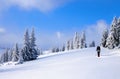 High on the mountains the man is going on the snowy fields and forests in cold snowy day. Royalty Free Stock Photo