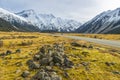 High mountains with snow at the top and highways in winter. The grass on the roadside is yellow in the National Park area