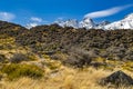 High mountains with snow on top in the winter, beautiful skies and clouds. The grass is yellow in Mount Cook Rd Royalty Free Stock Photo