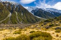 High mountains with snow on top in the winter, beautiful skies and clouds. The grass is yellow in Mount Cook Rd Royalty Free Stock Photo