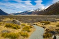High mountains with snow on top in the winter, blue skies and clouds. The grass is yellow in Mount Cook Rd Royalty Free Stock Photo