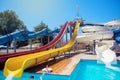 High multi-colored plastic slides in the form of swirling pipes in the water park