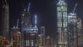 High multi-storey buildings under construction and cranes at night timelapse