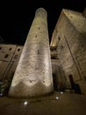 A high and narrow medieval tower of an old church, illuminated at night, located in a small town in Italy Royalty Free Stock Photo