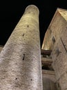 A high and narrow medieval tower of an old church, illuminated at night, located in a small town in Italy Royalty Free Stock Photo
