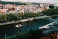 High perspective view of people crossing Zubizuri bridge in Bilbao, Spain - tilt shift selective focus effect