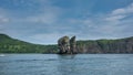 High picturesque rocks rise above the surface of the Pacific Ocean.