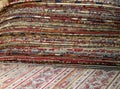 pile of many oriental carpets made of wool for sale in the shop Royalty Free Stock Photo