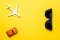 High plane toy in airplane travel concept. White aircraft, blue sunglasses and orange car toy on bright yellow backdrop in top Royalty Free Stock Photo