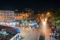 high point of view onto city street markets with people and vehicles blurred in motion