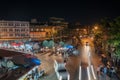 high point of view onto city street markets with people and vehicles blurred in motion