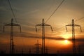 High power electric line towers at dramatic sunset Royalty Free Stock Photo