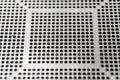 Close-up of used laser CNC high precision small pitch cut stencil for BGA chip reballing for electronics industry in partial focus Royalty Free Stock Photo