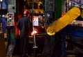 Hot iron in smeltery held by a worker.